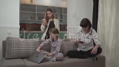 两个<strong>姐姐</strong>在手机上发短信，<strong>小</strong>女孩坐在家里的沙发上用笔记本电脑打字。 <strong>小</strong>可爱